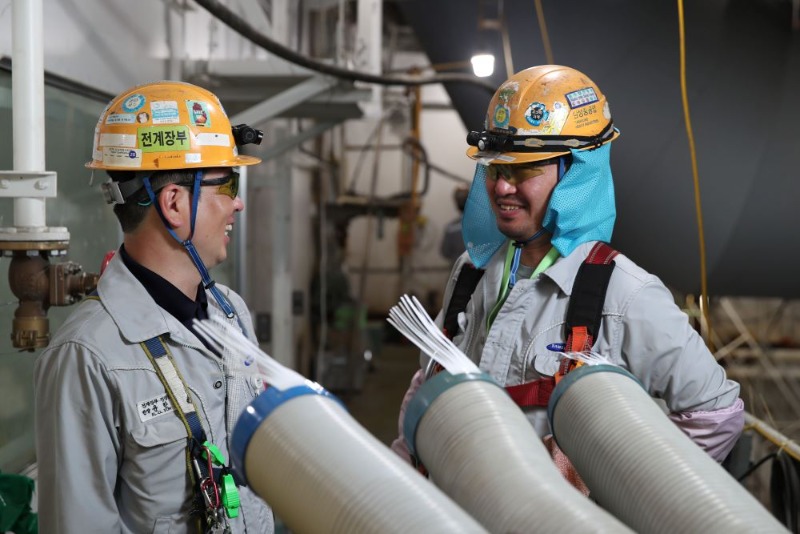 조선소 작업자들이 이동식 에어컨 앞에서 더위를 식히고 있다 2.jpg