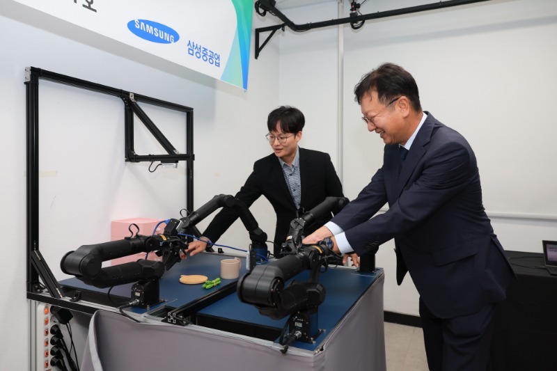 (사진 2) 최성안 삼성중공업 대표이사 부회장이 부산대학교 양팔모방학습로봇을 직접 체험해 보고 있는 모습.jpg